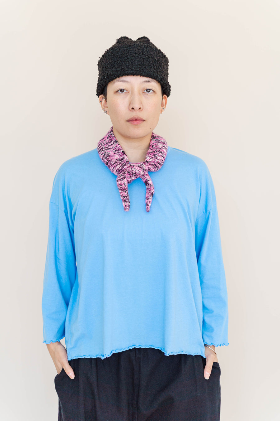 Front view of model Madison wearing the bright blue Nettle Studios Neptune Base Layer with lettuce hem and a knit scarf