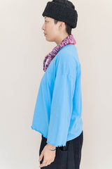 Side profile showing the relaxed drop-shoulder cut and long sleeves of the bright blue Nettle Studios Neptune Base Layer.