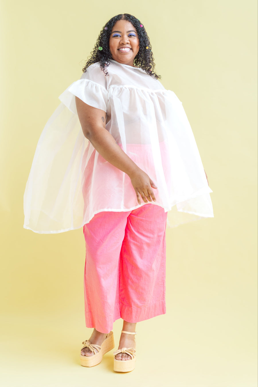 Side angle portrait highlighting the volumetric puff sleeves and floaty silhouette of the Nettle Studios Silk Organza Dress.