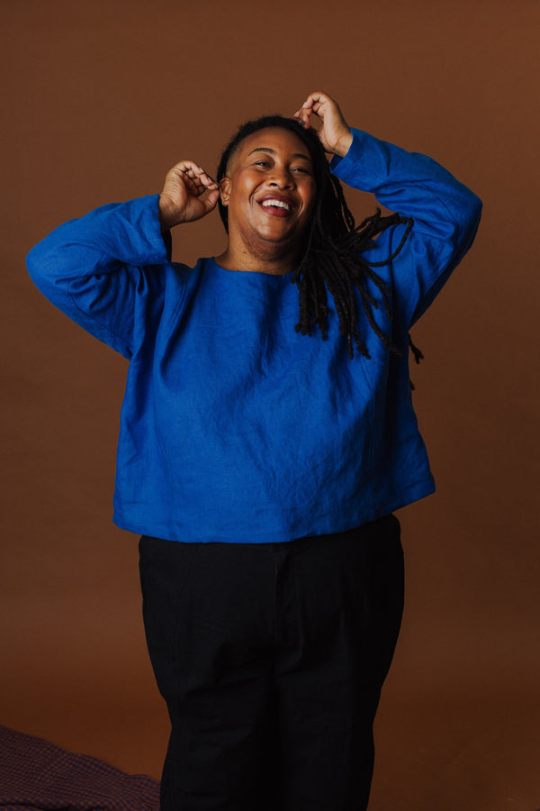 Ashley smiling while wearing the Molly Long Sleeve Top in Cobalt blue linen.
