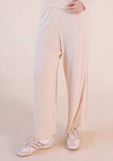 Front view focusing on the wide-leg drape and ribbed modal fabric of the Poplinen Hedy Lounge Pant in Heather Almond styled with sneakers.