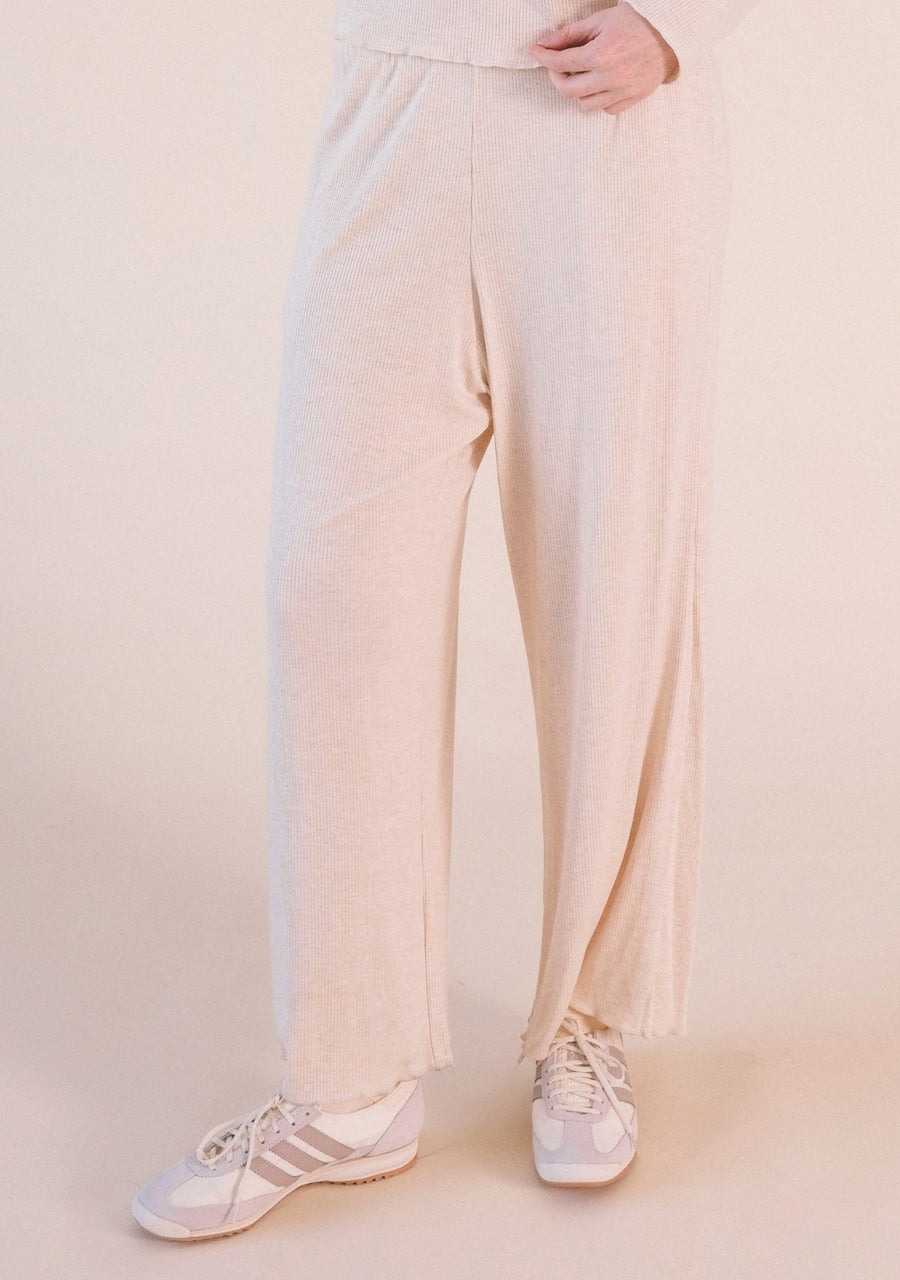 Front view focusing on the wide-leg drape and ribbed modal fabric of the Poplinen Hedy Lounge Pant in Heather Almond styled with sneakers.