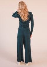 Rear view of a model showing the back fit and hem finish of the Poplinen Hedy Ribbed Modal Lounge Pant in Pine.
