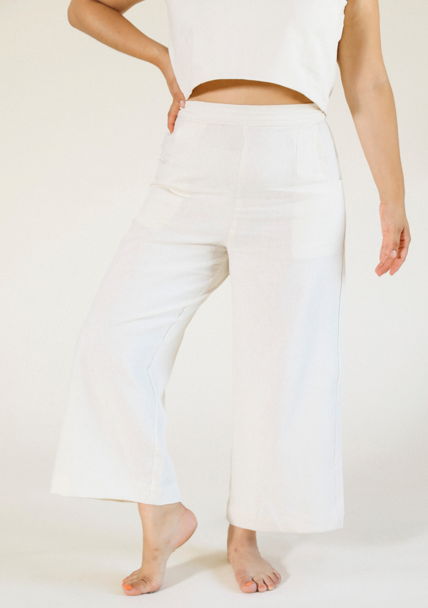 Front view of a model wearing the ivory white Poplinen Nin Linen Pant with a matching cropped top.