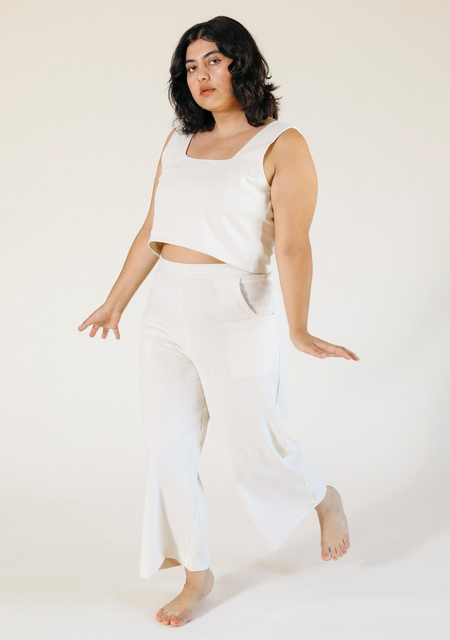 Full-length studio portrait of a model posing in the ivory Poplinen Nin Linen Pant and matching linen top.