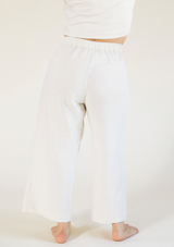 Rear view highlighting the cinched elastic back waistband and drape of the Poplinen Nin Linen Pant in Ivory.