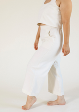 Side profile view showing the side pocket and relaxed silhouette of the Poplinen Nin Linen Pant in Ivory.