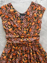 Close-up flat lay shot focusing on the gathered surplice V-neckline, cummerbund waistband, and Retrolicious brand tag