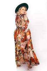 Side profile of model showing the flowing chiffon fabric and sheer long sleeves of the Sante Grace Autumn Queen Maxi Dress.