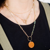 Model wearing the Sela Designs Elle Necklace styled in a multi-strand necklace stack with a pendant.