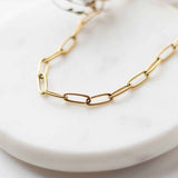 Close-up macro view of the interlocking gold-plated paperclip links on the Sela Designs Elle Necklace.