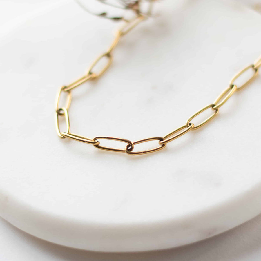 Close-up macro view of the interlocking gold-plated paperclip links on the Sela Designs Elle Necklace.