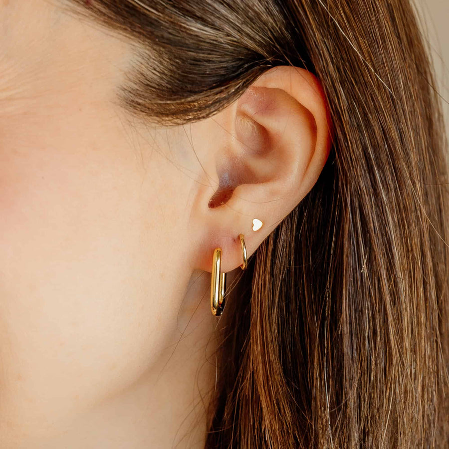 Close-up profile of a model wearing the gold Sela Designs Rectangle Everyday Hoop Earring in a lobe piercing.