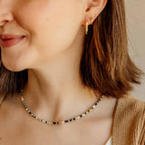 Model wearing the gold Sela Designs Rectangle Everyday Hoop Earring styled alongside a delicate beaded necklace.