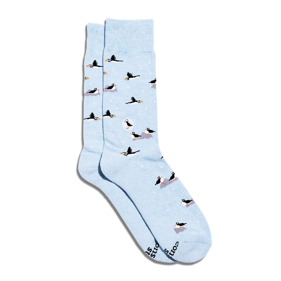 Studio flat lay shot of Conscious Step Socks That Protect Puffins showing the baby blue organic cotton body with flying and perching puffins.
