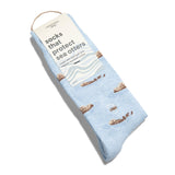 A single pair of light blue Conscious Step sea otter socks folded flat with a cream card stock packaging sleeve that reads "socks that protect sea otters made with fairtrade and organic certified cotton".