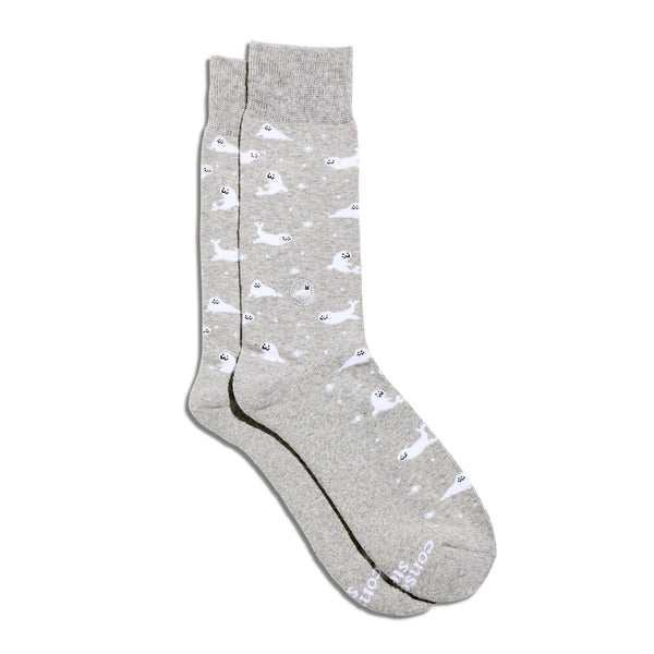 A pair of light gray organic cotton crew socks from Conscious Step featuring a white baby seal pattern and a small round embroidered seal patch on the ankle, shot on a plain white background.