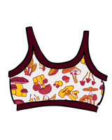 Illustrated flat lay of the Thunderpants USA Longline Bra featuring an allover mushroom print with deep red contrast binding.