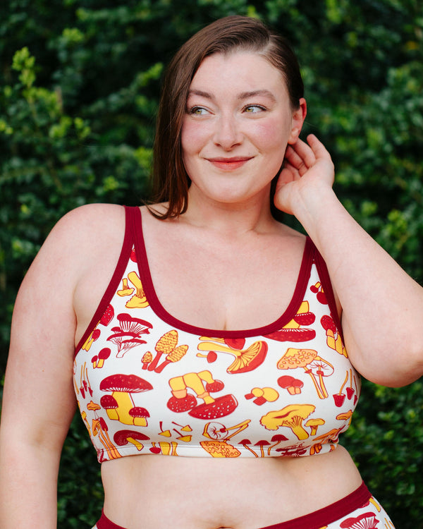 Close-up front view of model Jennice wearing the Thunderpants USA Longline Bra in size XL mushroom print.