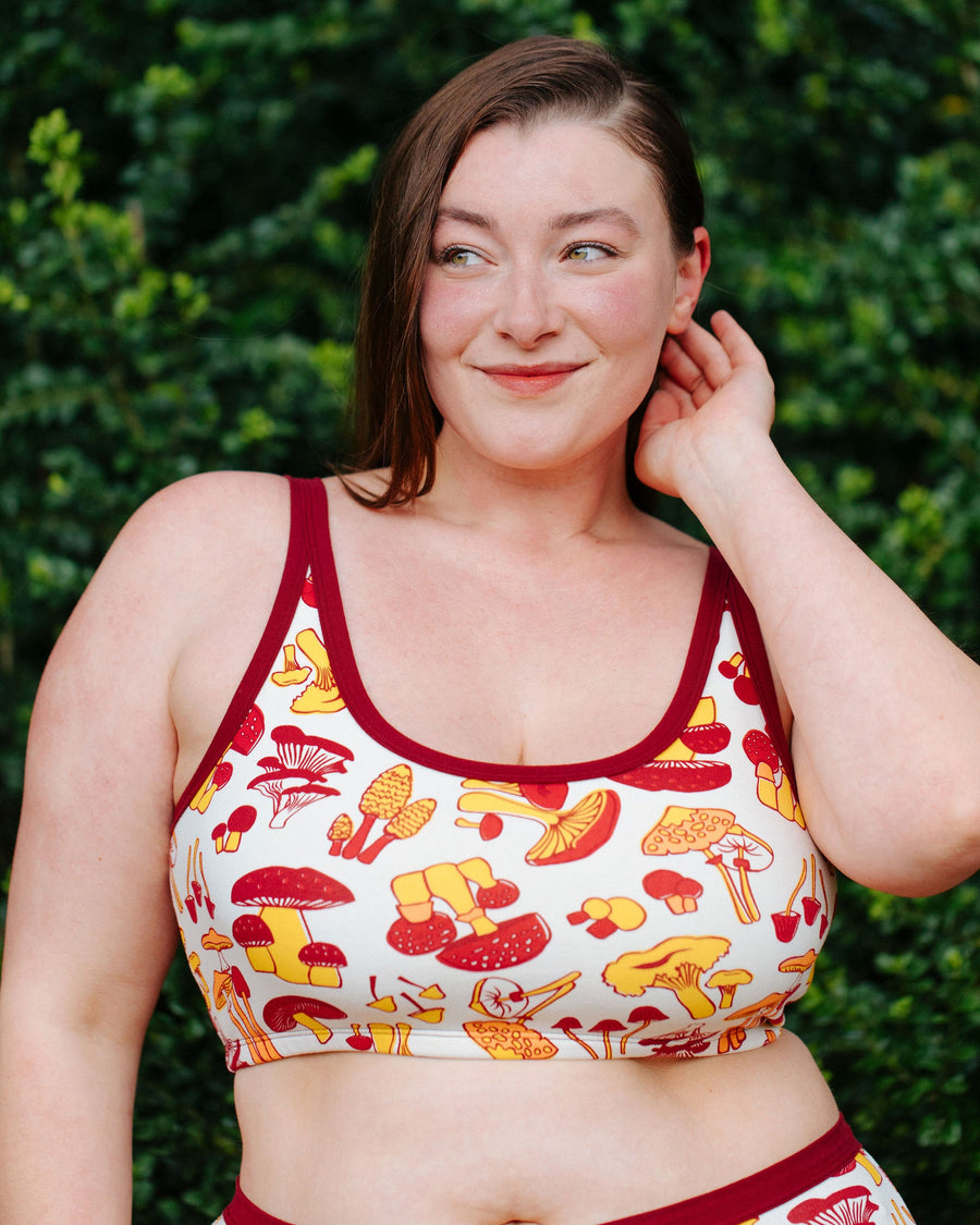 Close-up front view of model Jennice wearing the Thunderpants USA Longline Bra in size XL mushroom print.