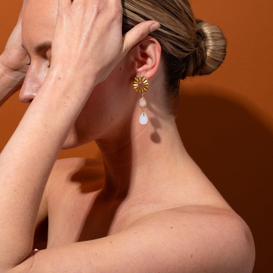 Side view model shot wearing the handmade Paloma Shell and Pink Jade Dangle earrings styled with a sleek hair bun.