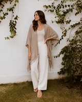 Model standing outdoors wearing the taupe Village Thrive Solid Color Rayon Kimono with hand on hip.