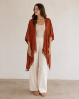Full-length view of model wearing the Village Thrive Solid Color Kimono in Terracotta styled over cream wide-leg pants.