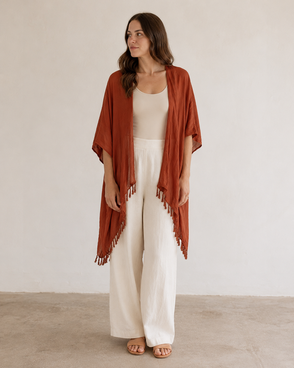 Full-length view of model wearing the Village Thrive Solid Color Kimono in Terracotta styled over cream wide-leg pants.