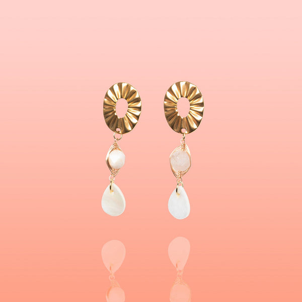 Pair of Tribe and Temple Paloma dangle earrings featuring gold oval posts, wire-wrapped light pink jade stones, and white teardrop shell pendants.
