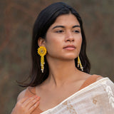 A model wearing the Sunflower Yellow DAHLIA Embroidered Earrings by Fyoli Fyoli, paired with a white and gold top. The handcrafted 3D flower and delicate beaded fringe add an elegant, nature-inspired touch to her look.